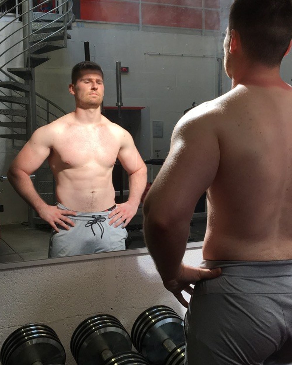 Nathan pendant sa prise de masse, face au miroir en salle